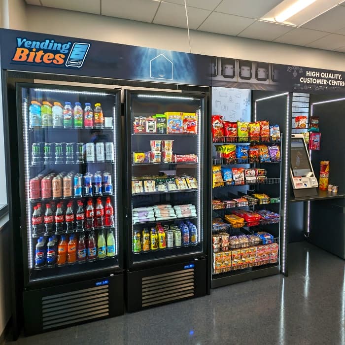 Branded drink coolers and a snack rack beside a self-checkout kiosk