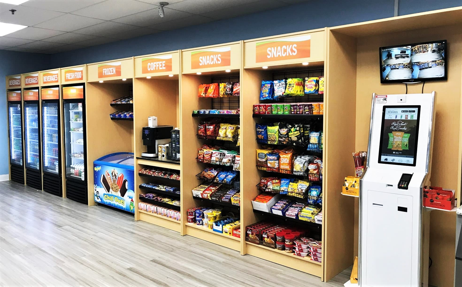 Full micro market wall with freezer, coffee, snack shelves and a self-checkout kiosk